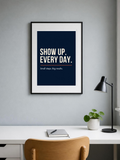 Show Up poster in a frame above a home office desk – room mockup